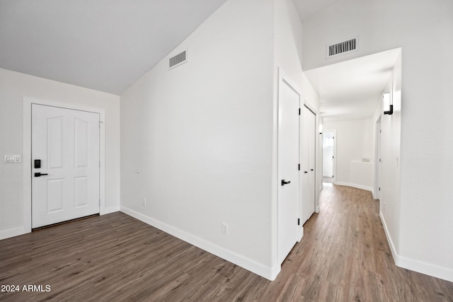 corridor featuring dark hardwood / wood-style flooring and lofted ceiling