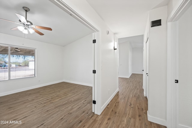 corridor with hardwood / wood-style flooring