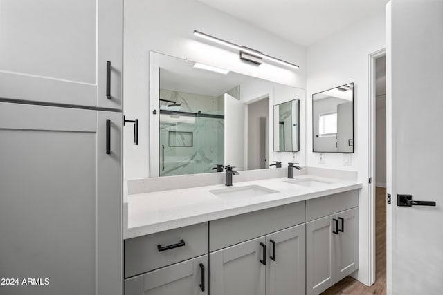 bathroom with hardwood / wood-style floors, vanity, and a shower with shower door