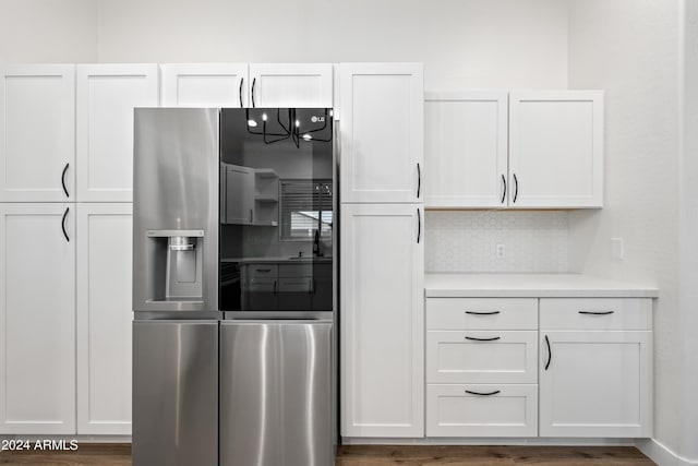 kitchen featuring white cabinetry, stainless steel fridge with ice dispenser, dark wood-type flooring, and tasteful backsplash