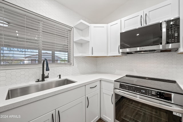 kitchen featuring stainless steel appliances, white cabinetry, tasteful backsplash, and sink