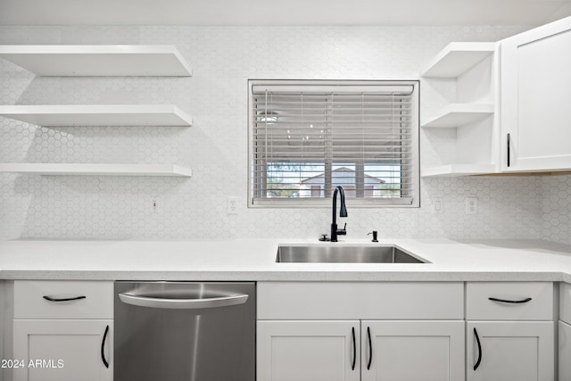 kitchen featuring decorative backsplash, dishwasher, white cabinets, and sink