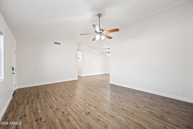 unfurnished living room featuring ceiling fan, dark hardwood / wood-style flooring, and vaulted ceiling