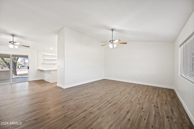 unfurnished living room featuring built in desk, vaulted ceiling, ceiling fan, and dark wood-type flooring