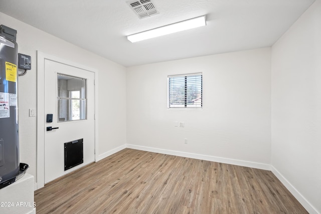 empty room featuring light hardwood / wood-style flooring and water heater