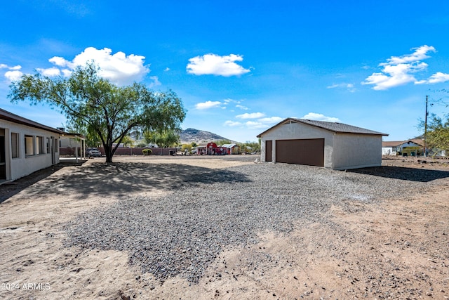 view of yard featuring an outbuilding, a mountain view, and a garage