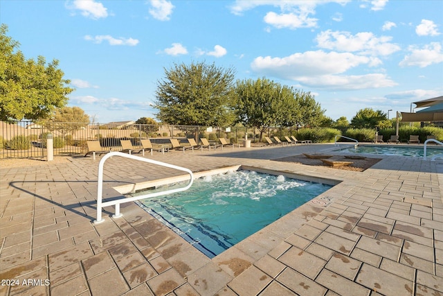 community pool with a patio and fence