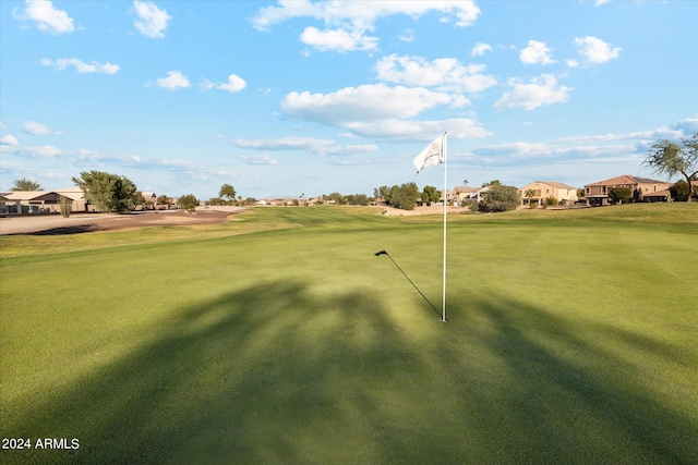 surrounding community featuring golf course view and a yard