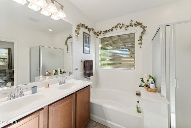 bathroom featuring a shower stall, a bath, double vanity, and a sink