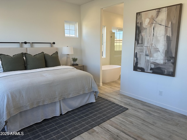 bedroom featuring ensuite bath and light hardwood / wood-style flooring