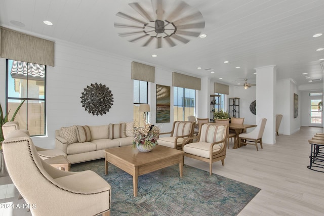 living room with crown molding, ceiling fan, and light hardwood / wood-style floors