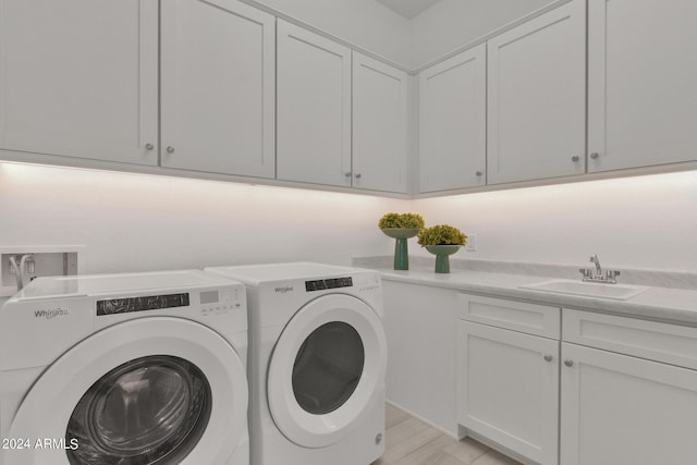 washroom with separate washer and dryer, sink, and cabinets