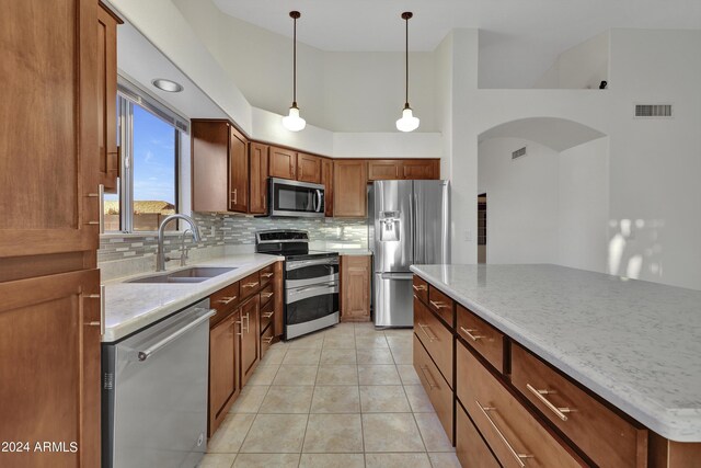 kitchen with pendant lighting, sink, appliances with stainless steel finishes, and decorative backsplash