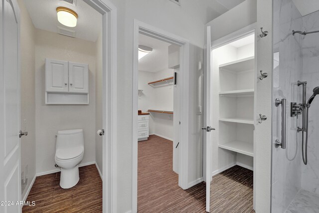 bathroom with toilet, hardwood / wood-style flooring, and walk in shower