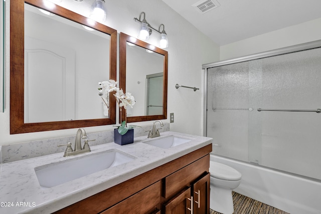 full bathroom with toilet, bath / shower combo with glass door, and vanity