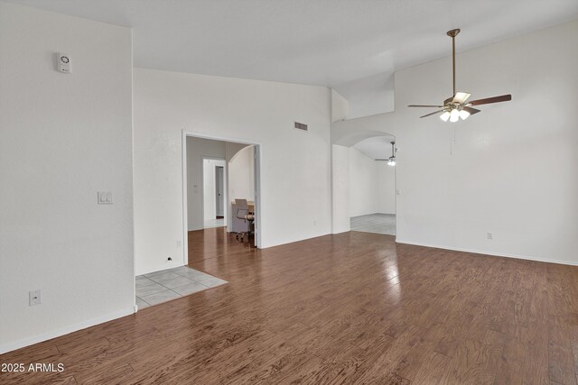 unfurnished living room with hardwood / wood-style flooring, high vaulted ceiling, a healthy amount of sunlight, and ceiling fan