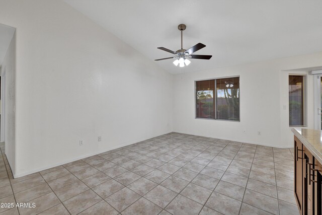 kitchen with backsplash, light tile patterned floors, stainless steel appliances, ceiling fan, and a kitchen island