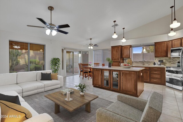 kitchen with vaulted ceiling, sink, a center island, ceiling fan, and appliances with stainless steel finishes