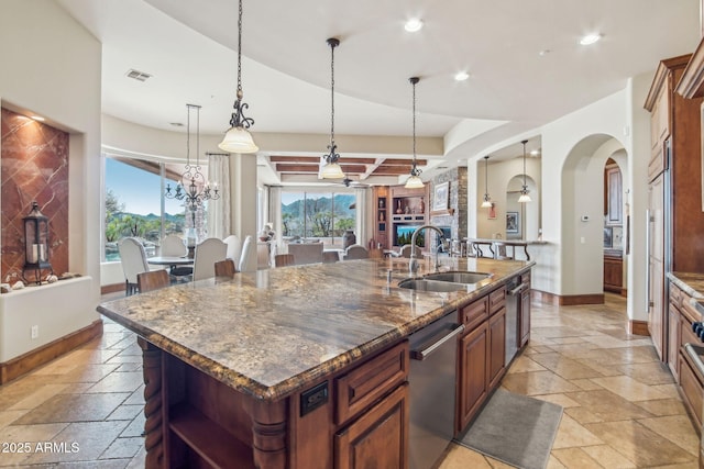 kitchen with a kitchen island with sink, stone tile floors, a sink, baseboards, and open shelves