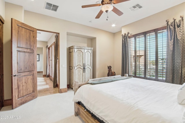 bedroom with a ceiling fan, visible vents, light carpet, and baseboards