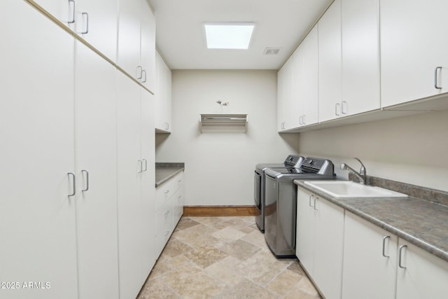 laundry area with cabinet space, visible vents, washer and clothes dryer, stone finish flooring, and a sink