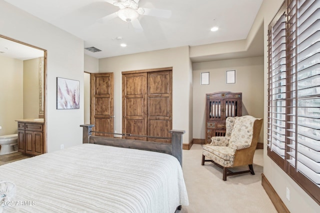 bedroom with recessed lighting, light carpet, visible vents, baseboards, and ensuite bath