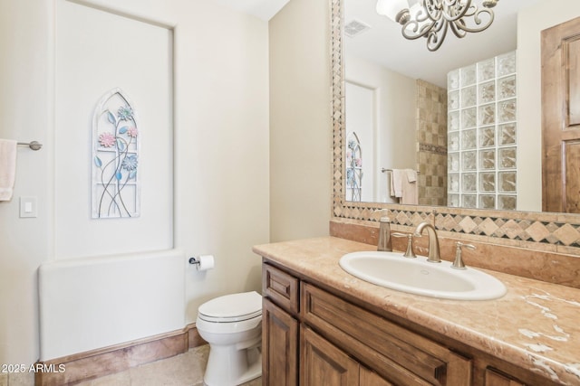 bathroom featuring visible vents, toilet, backsplash, vanity, and a notable chandelier