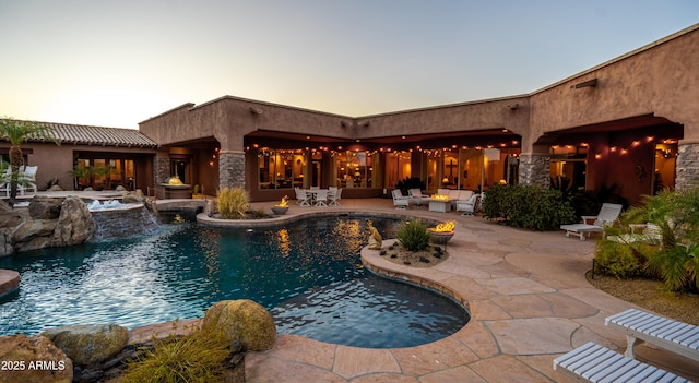 pool with an in ground hot tub, an outdoor hangout area, and a patio