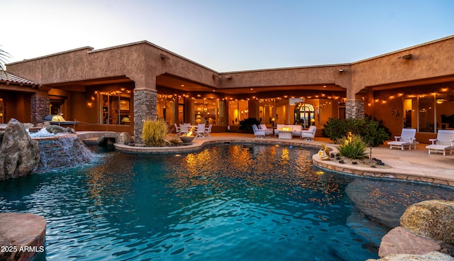 pool with a patio area and an outdoor hangout area