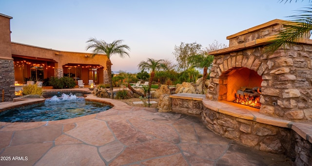 view of swimming pool featuring a patio area and an outdoor stone fireplace