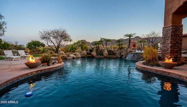 view of swimming pool with a patio area, an outdoor fire pit, and a mountain view