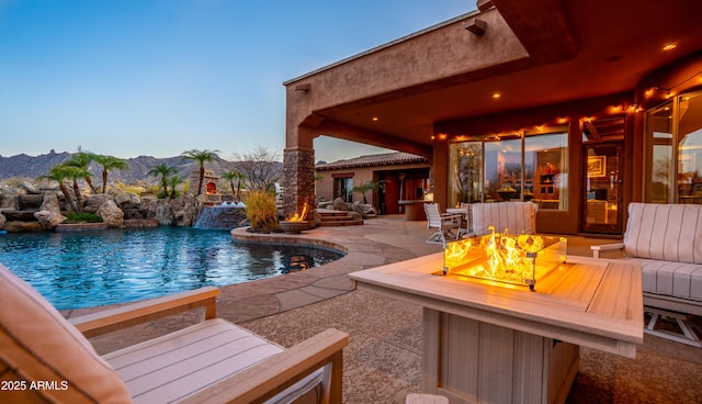 pool featuring a patio, a fire pit, and a mountain view