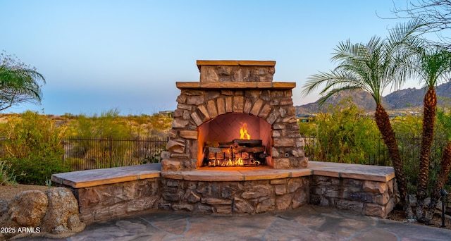 view of patio / terrace featuring fence and an outdoor stone fireplace