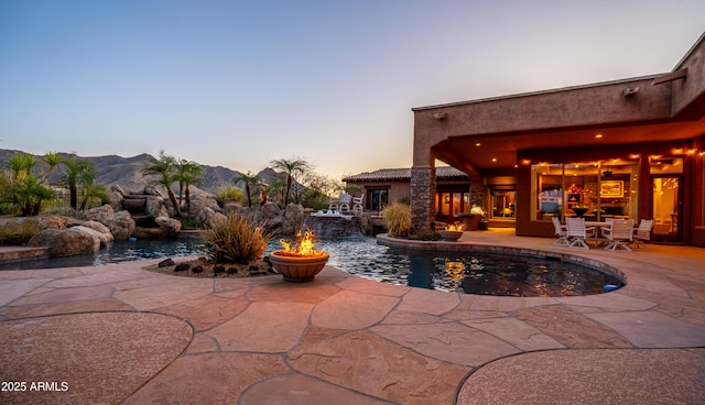 outdoor pool with a patio and a mountain view