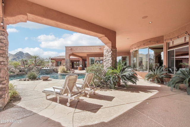 view of patio / terrace with a mountain view and an outdoor pool