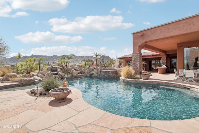 outdoor pool with a patio and a mountain view