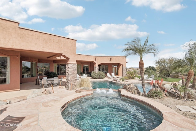 outdoor pool featuring a patio and an in ground hot tub