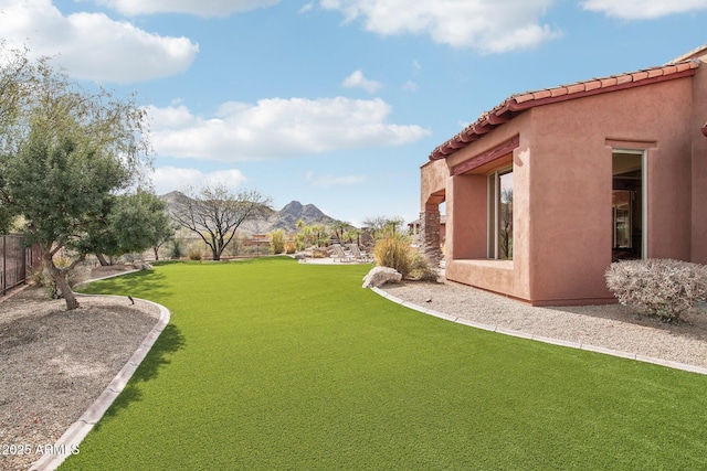 view of yard featuring fence and a mountain view