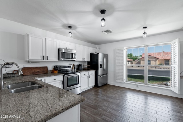5841 W Kesler St, Chandler, AZ 85226 - kitchen featuring stainless steel appliances, a sink, white cabinetry, and dark stone counters