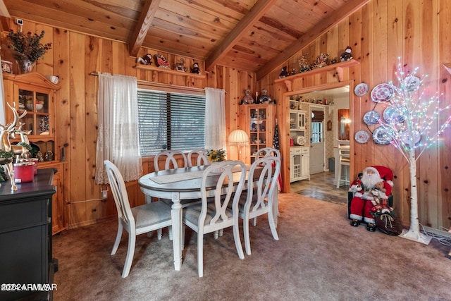 dining space with wood ceiling, carpet floors, wooden walls, and vaulted ceiling with beams