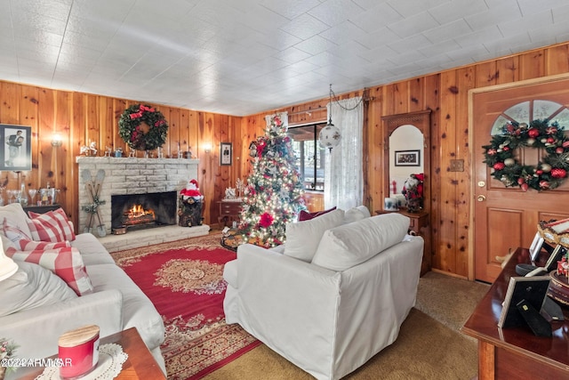 carpeted living room featuring a fireplace and wood walls