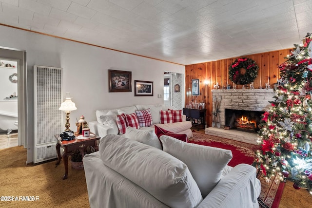 carpeted living room featuring wood walls, crown molding, and a fireplace