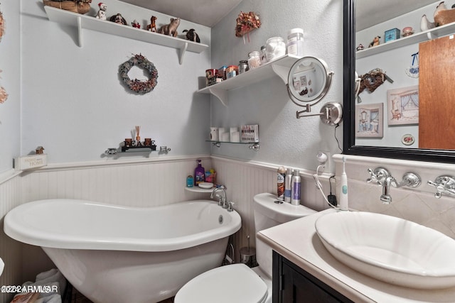 bathroom with a bath, vanity, and toilet