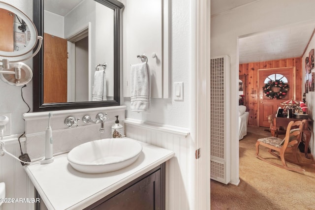 bathroom featuring wood walls and vanity