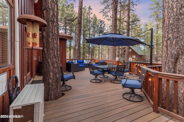 deck at dusk featuring an outdoor hangout area