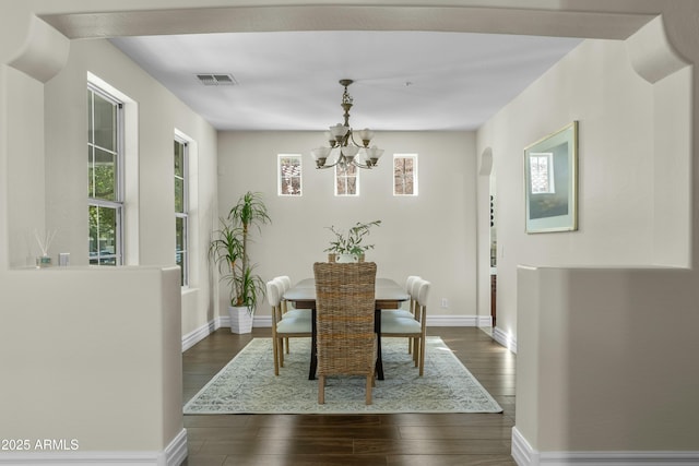 dining room featuring dark wood-style flooring, visible vents, baseboards, and an inviting chandelier