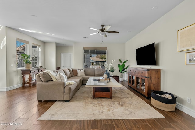 living room featuring a ceiling fan, baseboards, and wood finished floors