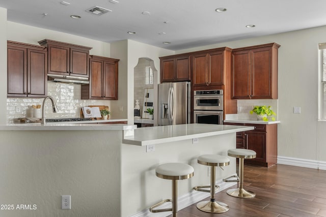 kitchen featuring visible vents, appliances with stainless steel finishes, light countertops, and dark wood-style flooring