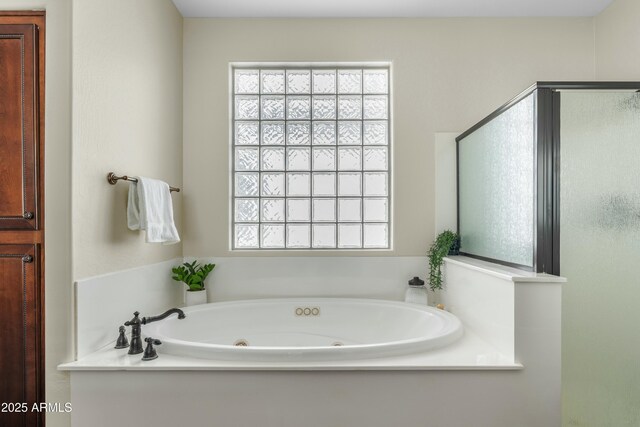 bathroom with a jetted tub and a shower stall