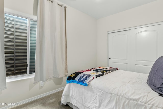 bedroom featuring carpet, baseboards, and a closet